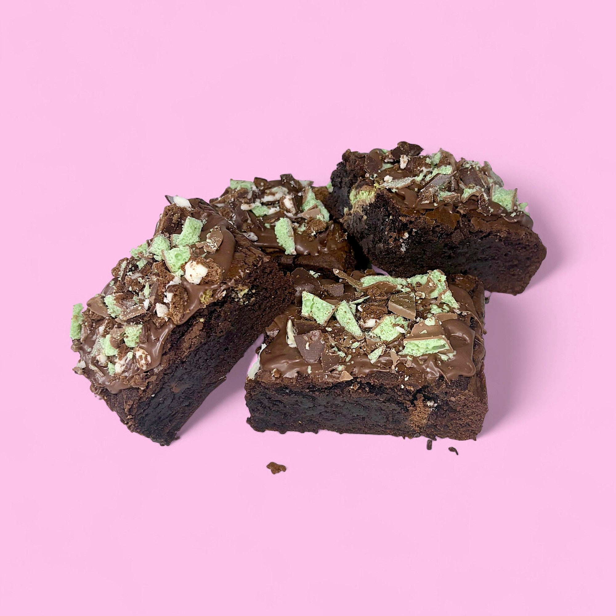 Chocolate brownies with mint chocolate chip topping on a pink background, made with real belgian chocolate