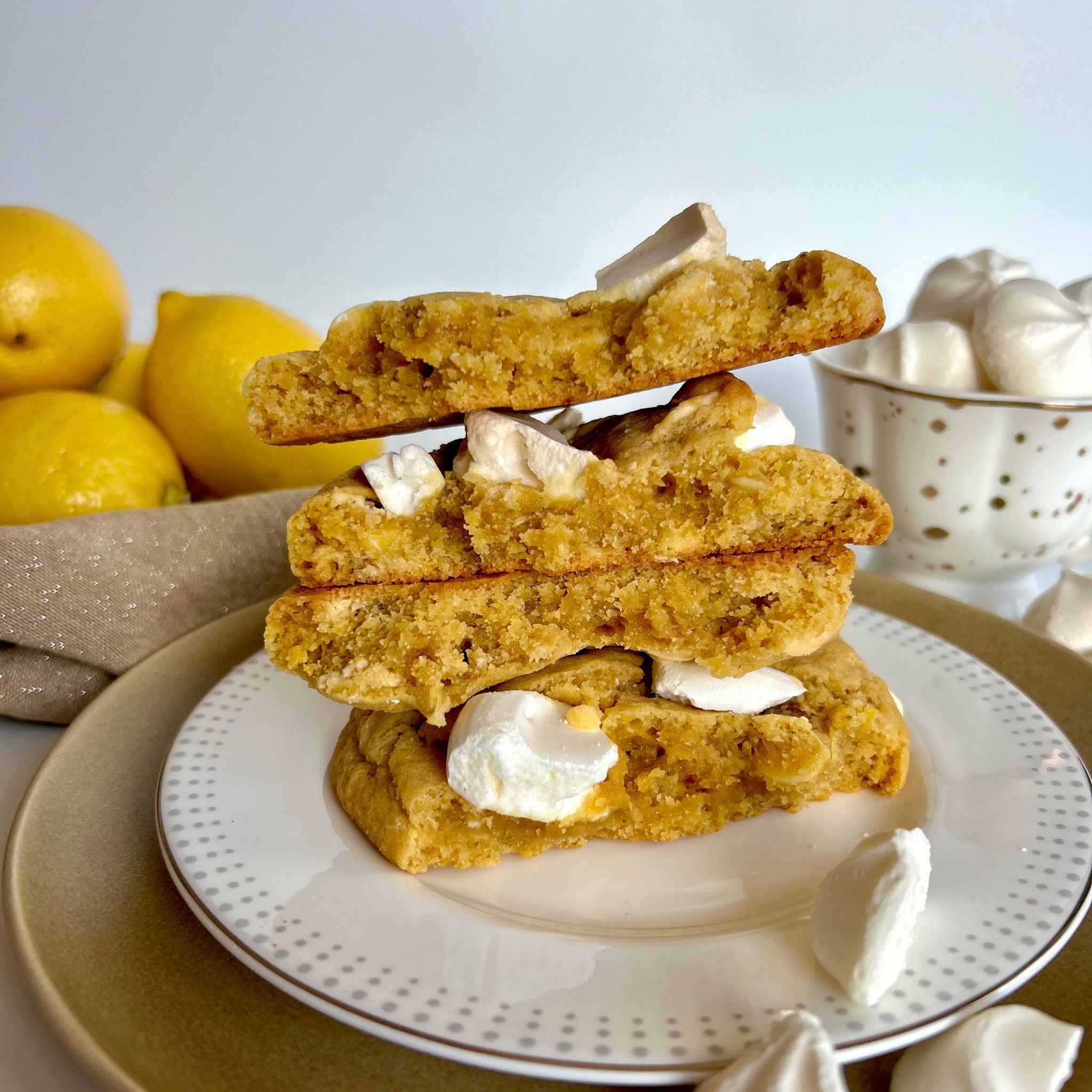 Lemon meringue cookies stacked high on a white plate