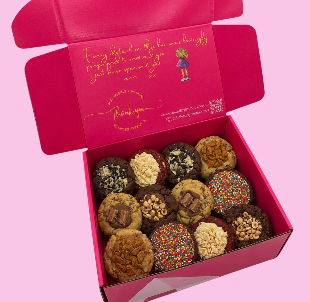Box of assorted cookies with a pink interior and decorative text on a pink background