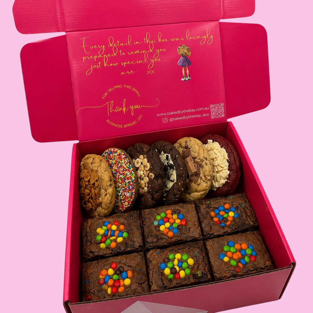 Box of assorted brownies and chunky cookies in open hot pink gift box