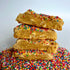 Side view of two funfetti cookies cut in half and stacked on top of each other on a base of sprinkles