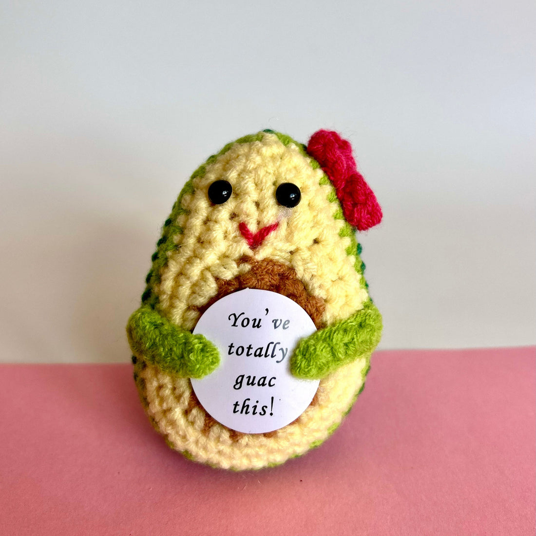 front view of a hand knitted avocado keepsake holding the message You&