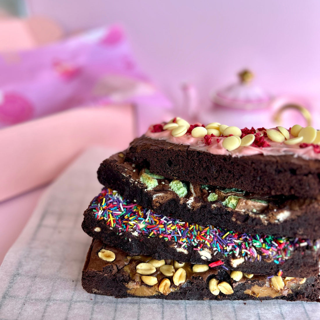 stack of 4 brownies with pink backdrop ready for gifting