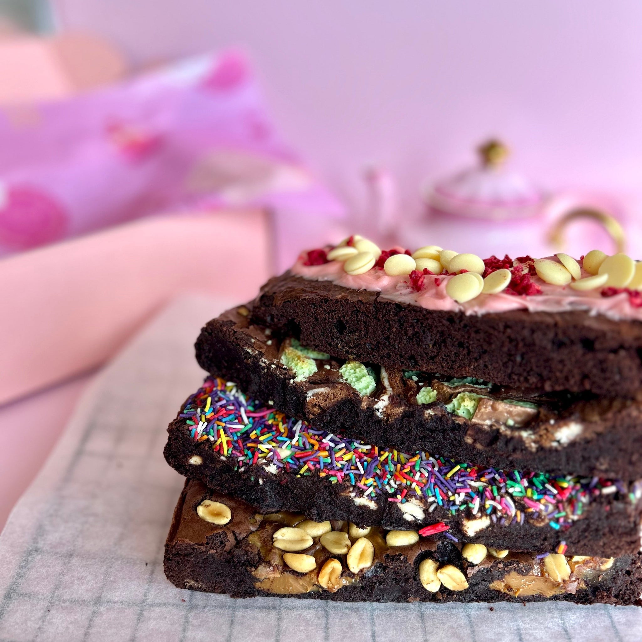 stack of 4 brownies with pink backdrop ready for gifting